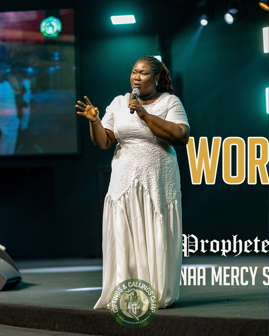 Mercy Sinclear singing on stage in a white dress