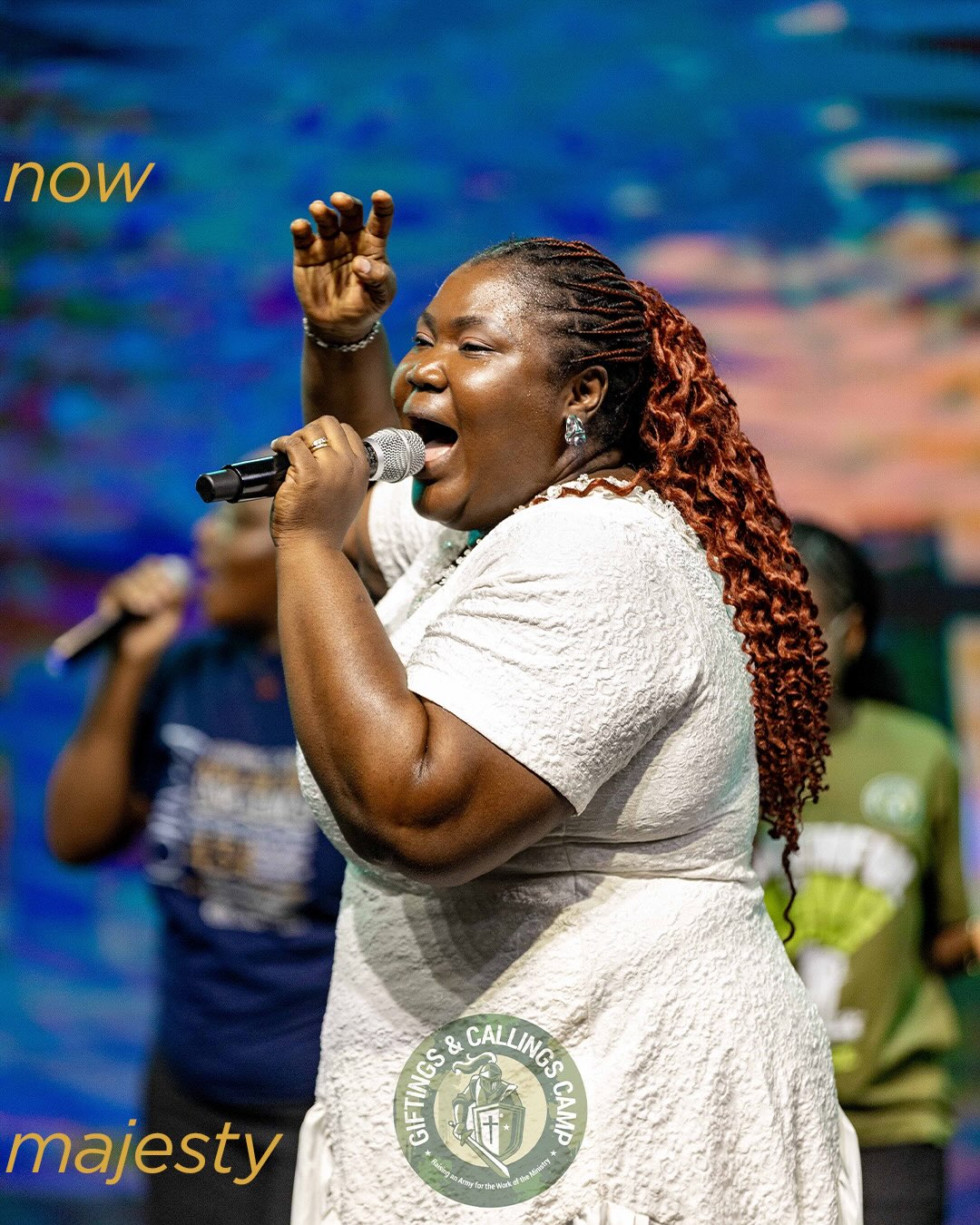 Mercy Sinclear singing into a microphone at a worship gathering